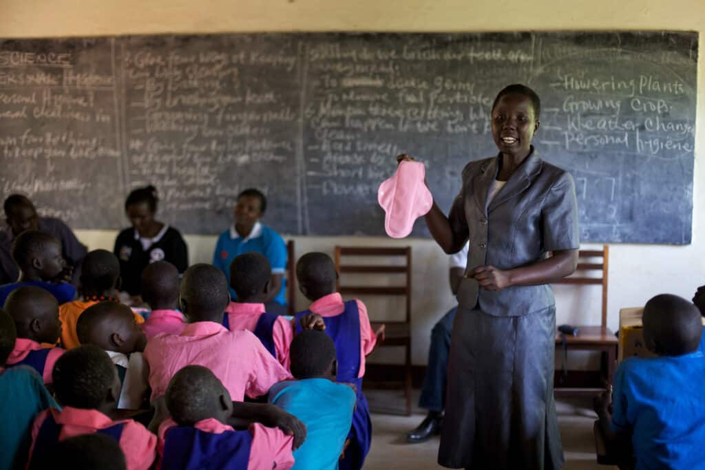 Women teaching schoolgirls how to use reusable pads. 