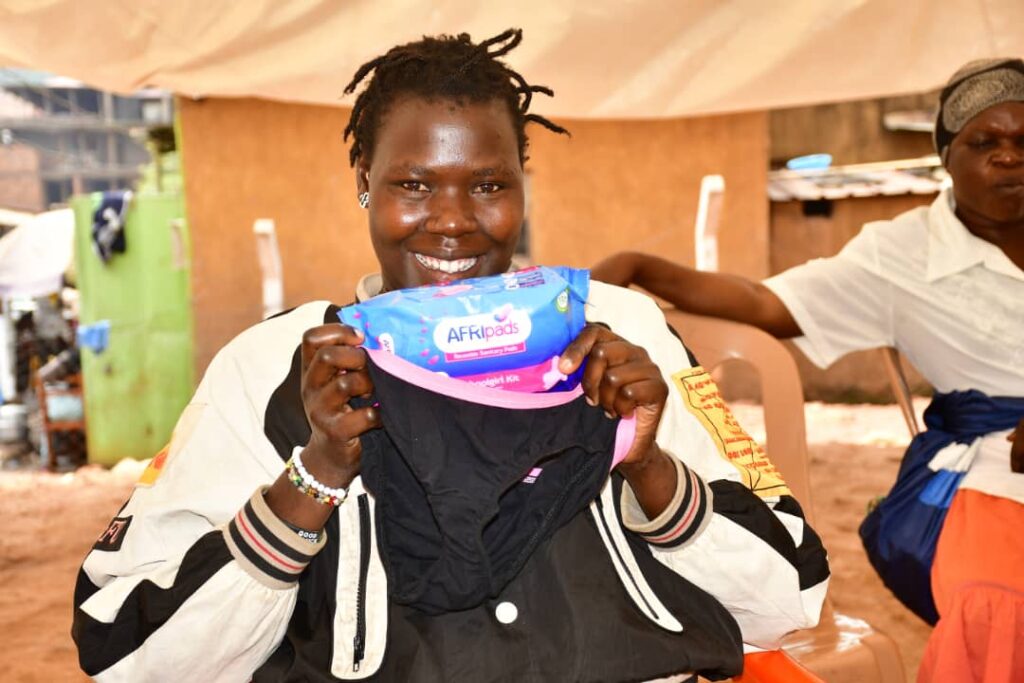 A Karimojong girl posing with AFRIpads Menstrual Kits and AFRIpads Underwear