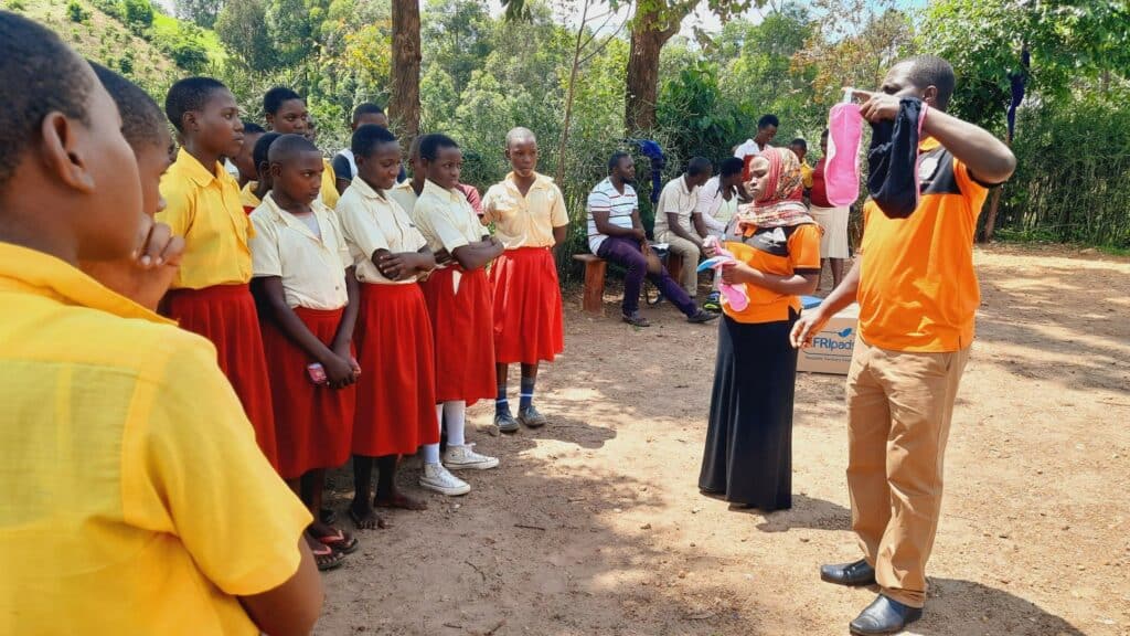 Male girl rights advocate demonstrating the use and care of AFRIpads reusable sanitary pads